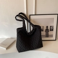 Primer plano del bolso tote acolchado negro con costuras en V y correa de hombro ancha - Negro