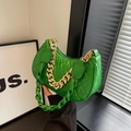 Green crescent shoulder bag with quilted pattern and gold chain strap shown on model - Green