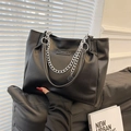 Details einer schwarzen Tote-Bag aus genarbtem Leder mit Silberkette und Logo - Schwarz