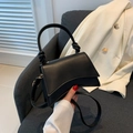 Détail de la poignée nouée et du cuir noir mat sur ce sac à main au style minimaliste - Noir