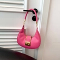 Detail of bright pink leather hobo bag with gold square buckle hanging on door - Pink