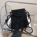 Detail view of a black fringe crossbody bag featuring suede texture and decorative tassels - Black