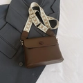 Bolso bandolera de cuero marrón oscuro con correa ancha étnica sobre traje gris - Marrón