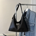 Detail of black hobo tote bag featuring a silver star emblem and metal chain strap - Black