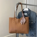 Close-up of a brown tote bag featuring decorative checkered scarf on a metal stand - Dark Brown