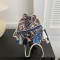 Detalle de bolso saco bohemio con patrones étnicos geométricos y borlas azules largas - Negro