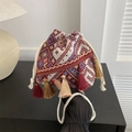 Detalle del bolso de cubo con cordón y patrones geométricos con detalles de flecos - Rojo