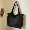 Minimalist black canvas tote bag with multiple pockets and silver metal snap button - Black