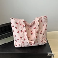 Pink corduroy tote bag with strawberry print on a desk next to a laptop - Pink