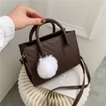 Dunkelbraune gesteppte Damenhandtasche mit weißem Kunstpelzanhänger und langem Schultergurt - Dunkelbraun
