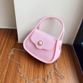 Pink jelly handbag with pearl buckle and golden chain strap in a soft home setting - Pink