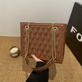 Elegant brown quilted shoulder bag with golden chain strap in a lifestyle setting - Dark Brown