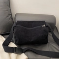 Black corduroy crossbody camera bag with adjustable wide strap shown in a lifestyle setting - Black
