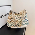 Makroansicht von gewelltem Strickmuster und geometrisch besticktem Gurt an der Tasche - Gebrochenes Weiß