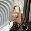 Brown crocodile embossed leather handbag featuring a unique gold wave metal clasp - Khaki