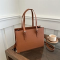 Detail view of brown Saffiano leather tote with adjustable handles and detachable strap - Dark Brown