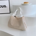 Dettaglio della borsa tote in paglia color crema con manici in tessuto bianco su sfondo - Bianco Sporco