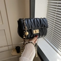 Detail einer schwarzen gesteppten Satteltasche mit Goldkette und Kugelverzierung - Schwarz