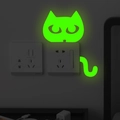 Luminous green cat wall sticker glowing in dark around a light switch socket - Cat Style (G020)