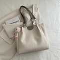 Minimalist beige tote bag with grey accents and plush charm on a blazer background - With Pink Plush Pendant / Licorice Green