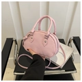 Vista ravvicinata di una mini borsa rosa con zip argentata e dettagli in borchie - Rosa Con Pendente