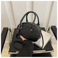 Dettaglio di una borsa semicircolare nera in pelle PU con doppi manici e tracolla regolabile - Nero Con Pendente