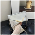 Detail van zilveren enveloppe-clutch met metaaltextuur en gouden ketting - Zilver