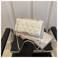 Close-up of white quilted leather crossbody bag with gold hardware and chain strap - White