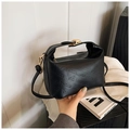Detail of black leather bag with rich rabbit embossed text and golden metal lock - Black