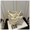 Close-up of cream PU leather bucket bag featuring a bow tie design and shoulder strap - Off White