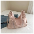 Dettaglio della borsa tote rosa a pieghe con cerniere metalliche decorative e fiocchi - Rosa