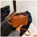 Detail of caramel brown crossbody bag featuring rich rabbit letter embossing and gold lock - Brown