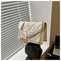 Detail of white quilted crossbody bag featuring golden S logo and long metal tassel - White