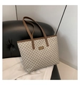 Detalle del bolso tote de lona con ribete de cuero marrón y etiqueta de moda - Caqui