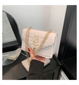 Detail van een crèmewitte handtas met krokodillenpatroon en een gouden kettingriem - Wit
