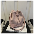 Detail of pink drawstring bucket bag with silver metal chain on white books - Pink