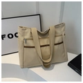 Dettaglio della borsa tote in tela beige con tasca metallica e nastri marroni applicati - Cachi