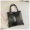 Close-up of black crocodile pattern faux leather tote bag with glossy finish and top handle - Black