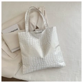 Close-up of white crocodile pattern tote bag with gold metallic texture on blazer - White