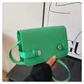 Macro detail of vibrant green leather handbag with silver metal buckles and flap design - Green