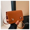 Detailed view of brown leather crossbody bag with silver pointed metallic hardware - Brown