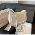 Detalle de bolso de hombro blanco de piel con herrajes dorados en elegante caja de regalo - Blanco Roto