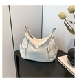 Dettaglio della borsa tote con motivo marmo bianco panna con cerniere argentate e tasche laterali - Bianco