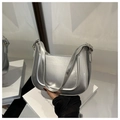 Primer plano de un bolso de hombro plateado en forma de media luna con acabado metálico - Plateado