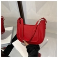 Detalle de un bolso de hombro en charol rojo brillante con elegantes curvas en U - Rojo