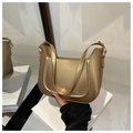 Detalle de bolso de axila minimalista en oro metálico con textura brillante y pliegues en U - Dorado