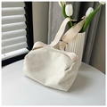 Bolso bandolera de pana beige con correa ajustable sobre una mesa blanca minimalista - Blanco
