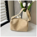 Beige corduroy crossbody pillow bag with wide strap and zipper closure in cozy setting - Khaki