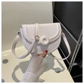 Detalle de un bolso de silla crema con una gran hebilla decorativa redonda elegante - Blanco