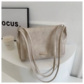 Dettaglio della borsa tote retrò in pelle crema con finiture dorate su podio - Beige